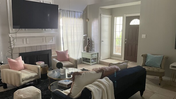 Un salon avec une cheminée, un téléviseur et une porte donnant sur l’extérieur.
