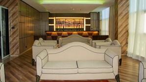 A modern lounge area with a central bar, cushioned seating, and a wooden floor. - Galaxy La Palm Royal Hotel (Port Harcourt)