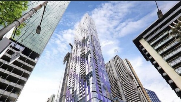 A modern high-rise building with a glass facade, surrounded by other tall buildings and trees. - 3 bedroom apartment in the heart of the CBD. (Melbourne)