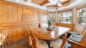 A dining area with a wooden table, chairs, and a bench.