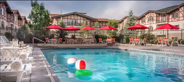 Relax by the pool surrounded by lounge chairs and umbrellas.