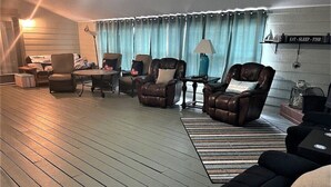 Un salon confortable avec des fauteuils inclinables en cuir, une table basse et un tapis.