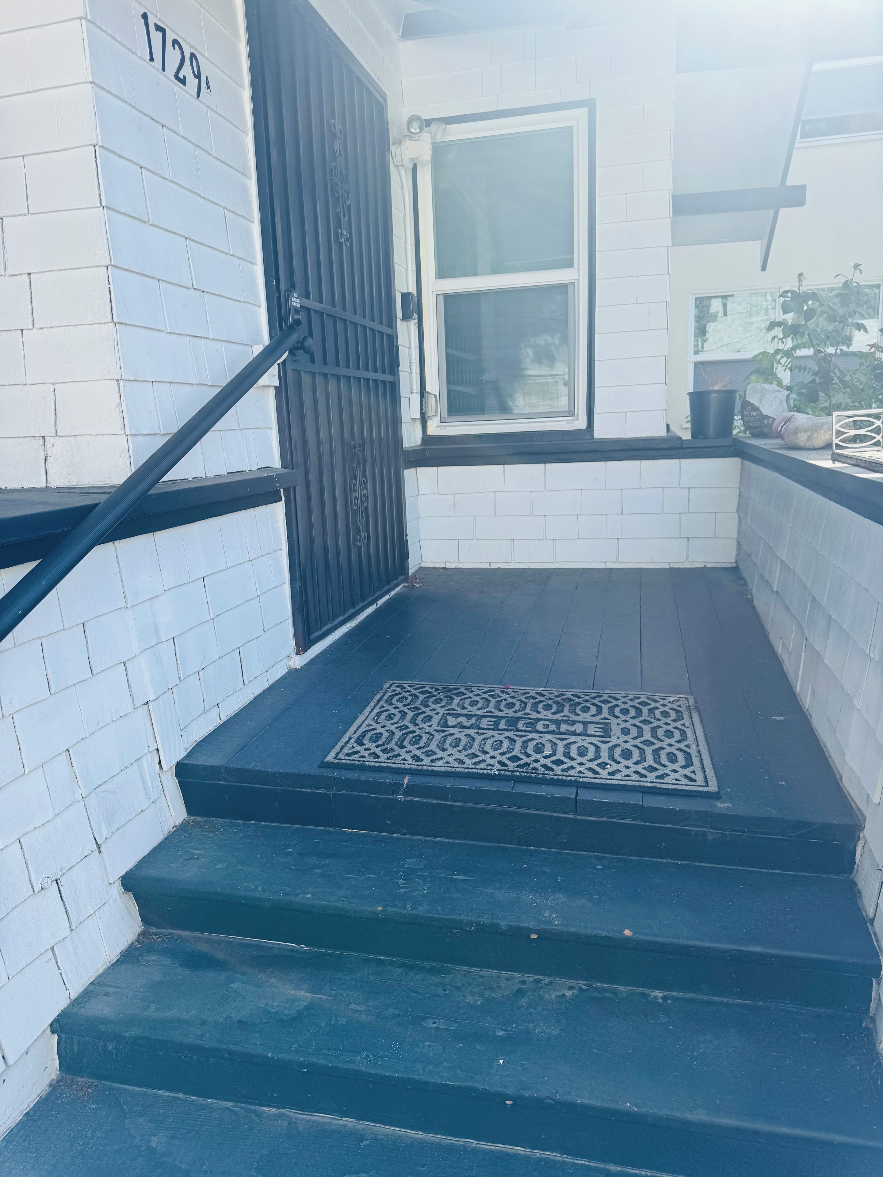 A set of black stairs leading to a door with a number '1729' on the wall.