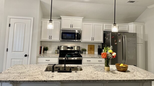 A kitchen with white cabinets, stainless steel appliances, a granite countertop, and pendant lighting. - Modern Ranch-Style Retreat — Prime location for the Course ⛳️ (Augusta)