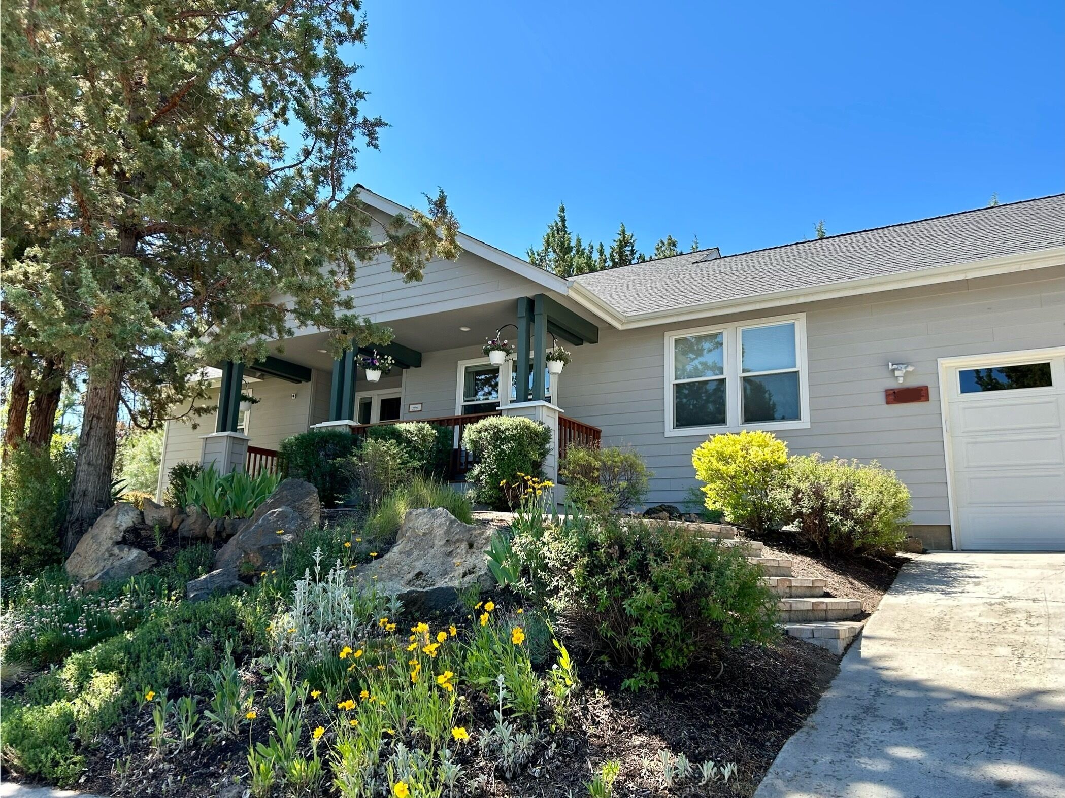 A residential house with a front porch, a covered entryway, and a driveway leading to a garage.