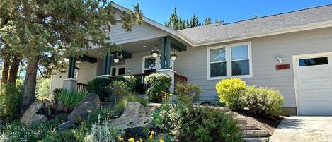A residential house with a front porch, a covered entryway, and a driveway leading to a garage.