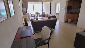 Amplia sala de estar con balcón, una mesa de comedor y zona de cocina.