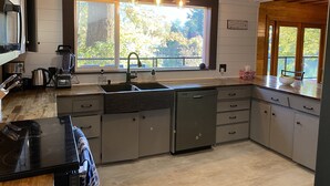 Una cocina moderna con un ventanal grande, lavavajillas empotrado y microondas.