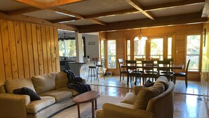 Un salón amplio con un conjunto de sofás, una mesa de centro y una mesa de comedor con sillas.