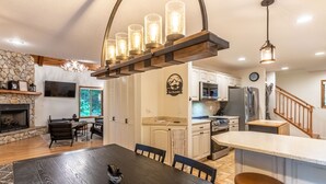 A modern kitchen with white cabinets, a stainless steel refrigerator, and a wooden island.