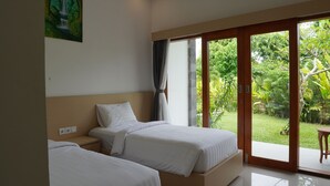 A hotel room with two beds, a large sliding glass door leading to a garden. - Artaloka Hotel & Restaurant (Penida Island)