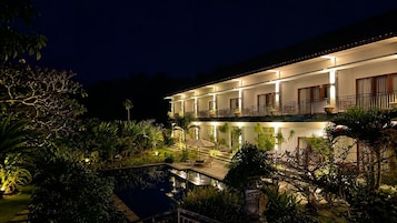 Un hotel de varios pisos con piscina y zona de estar al aire libre.