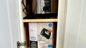 A kitchen cabinet with a stainless steel pot, a handheld electric mixer, and a blender box. - Disneyland/Knott's, 5BR 4BA, No Tax, Large Parking (Fullerton)