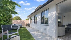 A modern house with a patio, outdoor furniture, and a large window. - Disneyland/Knott's, 5BR 4BA, No Tax, Large Parking (Fullerton)
