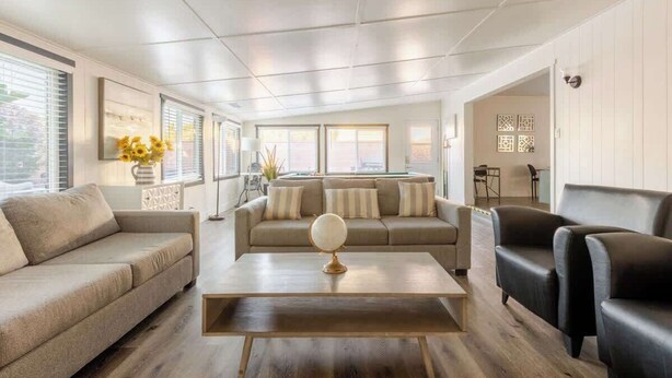 A modern living room with a sofa, armchairs, a coffee table, and a globe centerpiece. - Disneyland/Knott's, 5BR 4BA, No Tax, Large Parking (Fullerton)