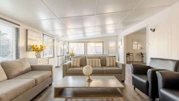 Un salon moderne comprenant un canapé, des fauteuils, une table basse et un globe décoratif.