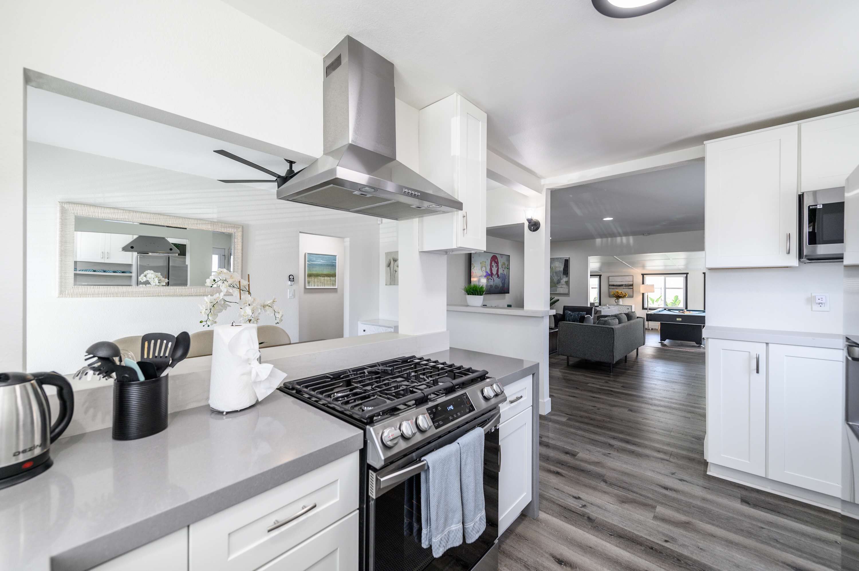 A modern kitchen with a gas stove, oven, and stainless steel range hood.