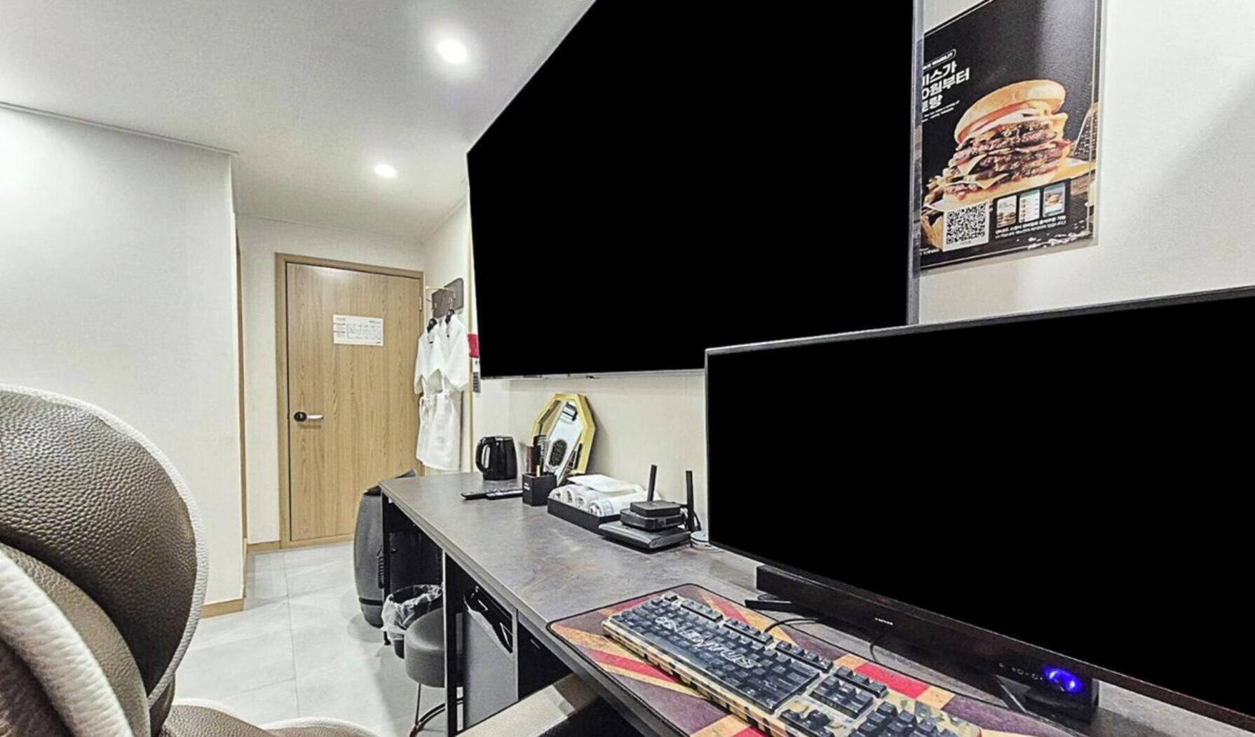 A modern office space with a desk, computer, and a large monitor.