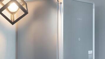 A modern, minimalist room with a built-in air conditioning unit labeled 'COWAY' and a geometric pendant light fixture.