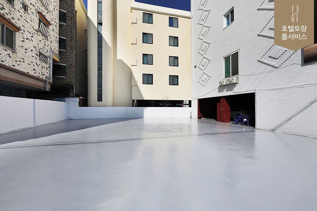 Un edificio moderno con techo plano y un amplio espacio abierto al frente.