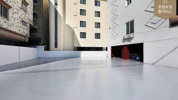 Un edificio moderno con techo plano y un amplio espacio abierto al frente.