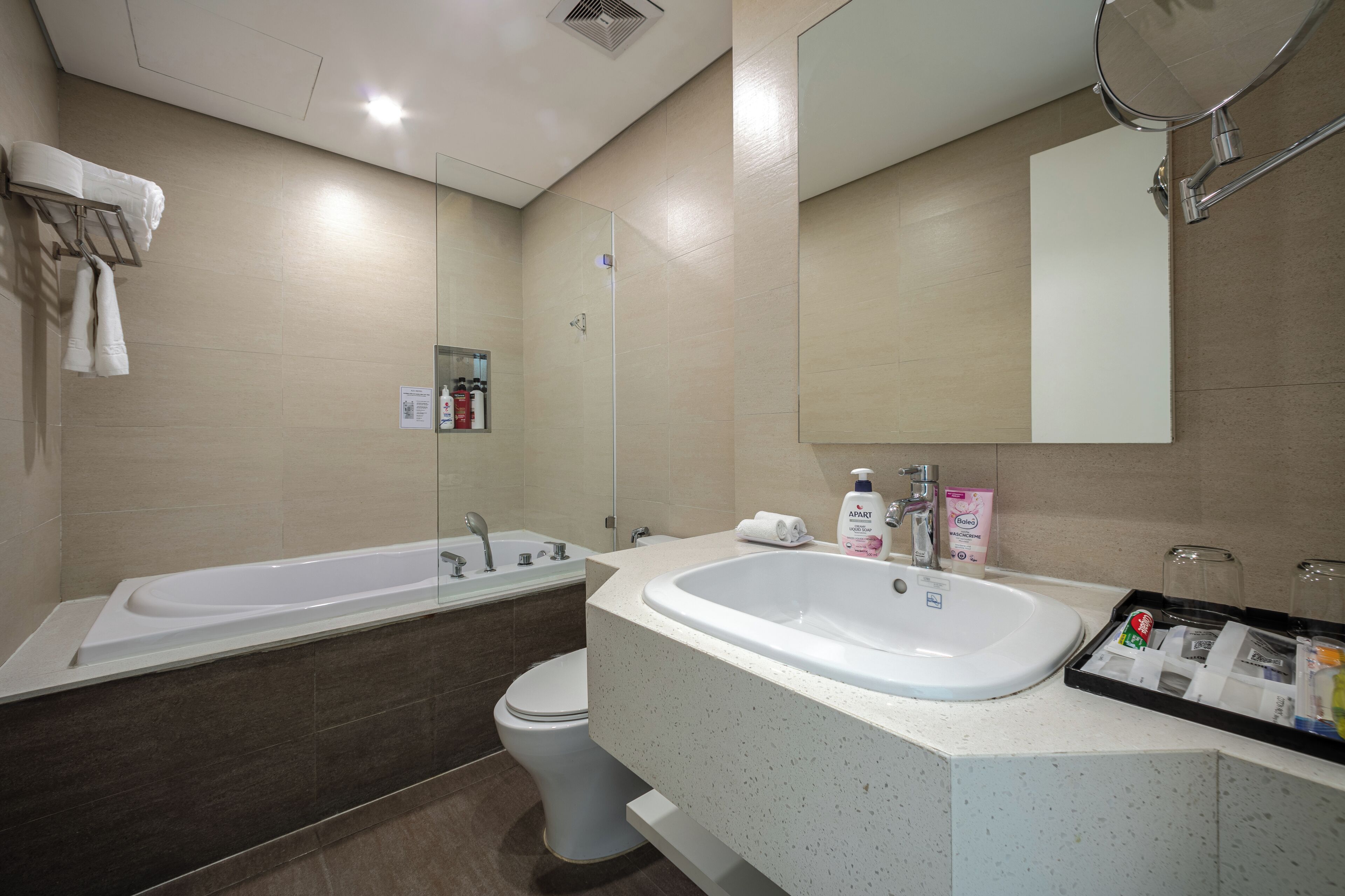 A modern bathroom with a bathtub, toilet, and sink.