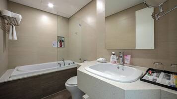 A modern bathroom with a bathtub, toilet, and sink.