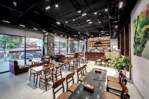 Um café moderno com assentos de couro, mesas de madeira e uma seleção de vinhos.