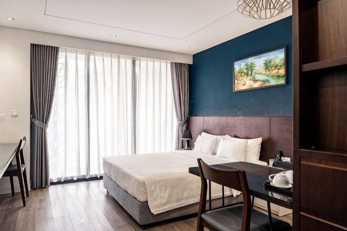 A hotel room with a bed, a desk, and a chair.