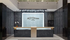 Una recepción con fondo de mármol y el nombre "ASTONINN CILACAP".