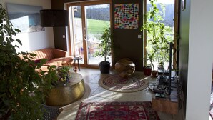 Ein geräumiges Wohnzimmer mit großem Fenster, einem Sofa, einem Couchtisch und einem Teppich.