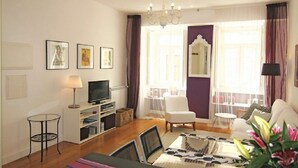 A living room with a television, a small table, a chair, and a sofa. - Graça Terrace (Lisboa)