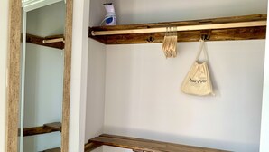 Ein Zimmer mit Holzschrank, Spiegel und einer Tasche mit dem Aufdruck 'Fön'.