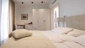 A hotel room with a large bed, a desk, and a wardrobe. - Hotel Magdalena (Zagreb)