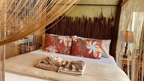 A bed with a canopy, pillows, and a folded towel. - Waikiki Living, 4 blocks from surf, mountain views, king size bed and office! (Honolulu)