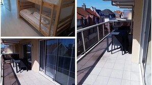 A balcony with a glass door, a small table, and a chair. - Superb T2 Hyper center Le Touquet (Le Touquet-Paris-Plage)
