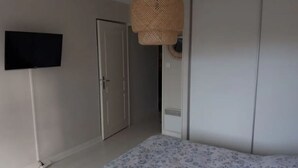 A bedroom with a bed, wardrobe, and a television on the wall. - Superb T2 Hyper center Le Touquet (Le Touquet-Paris-Plage)