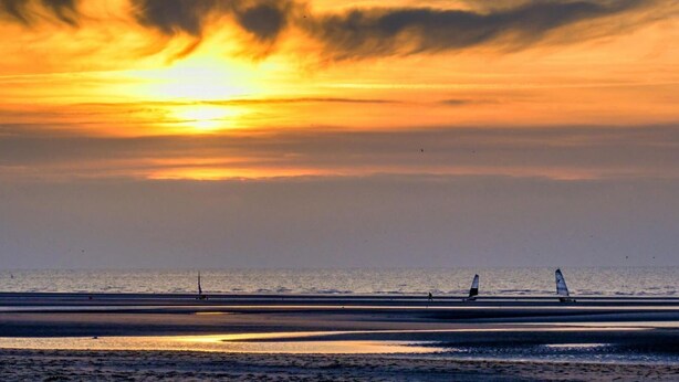 A sunset over a beach with two sailboats. - Superb T2 Hyper center Le Touquet (Le Touquet-Paris-Plage)