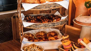 En frukostbuffé med croissanter, bakverk och munkar.