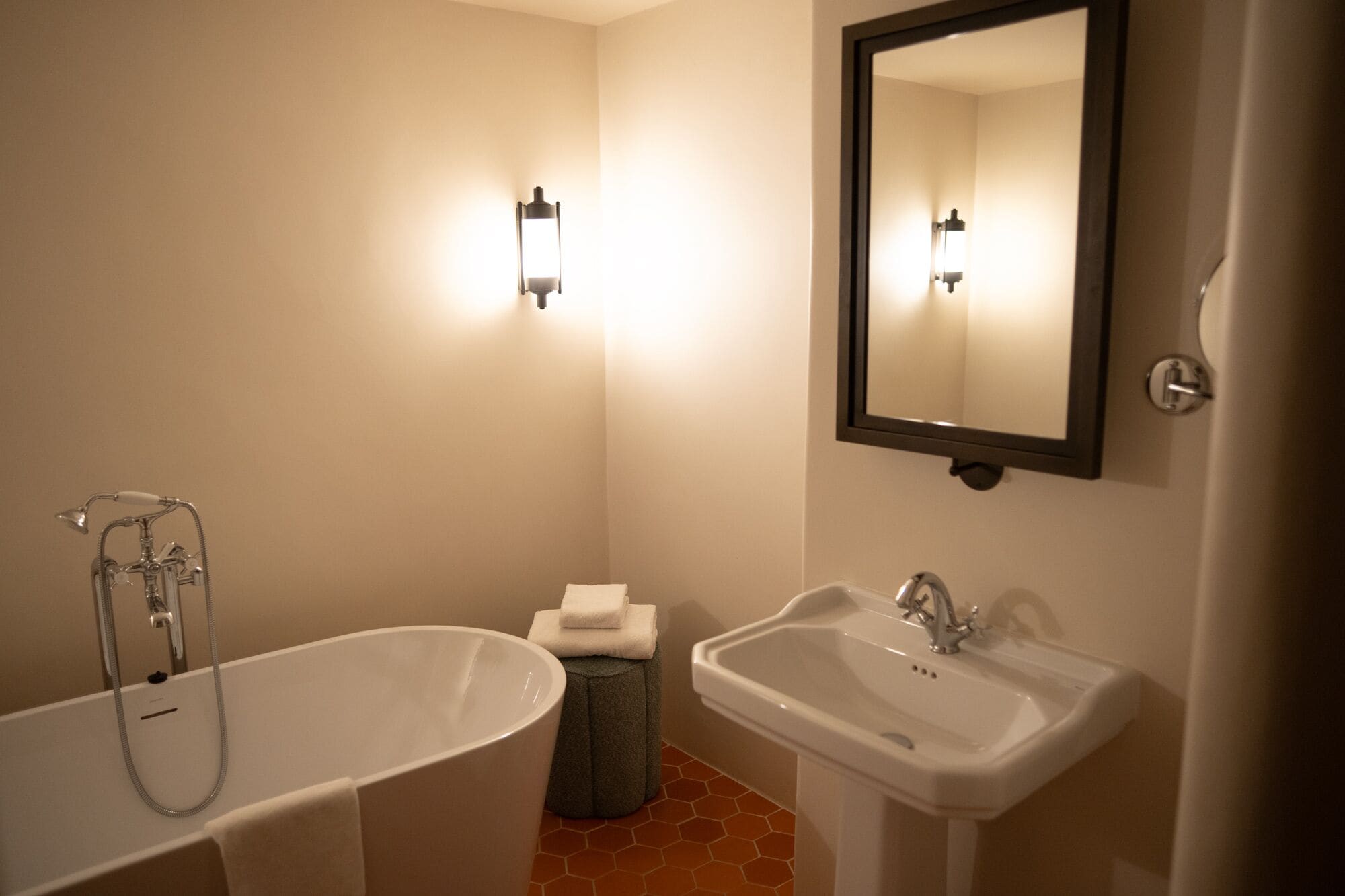 A bathroom with a bathtub, a sink, and a mirror.