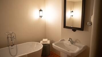 A bathroom with a bathtub, a sink, and a mirror.