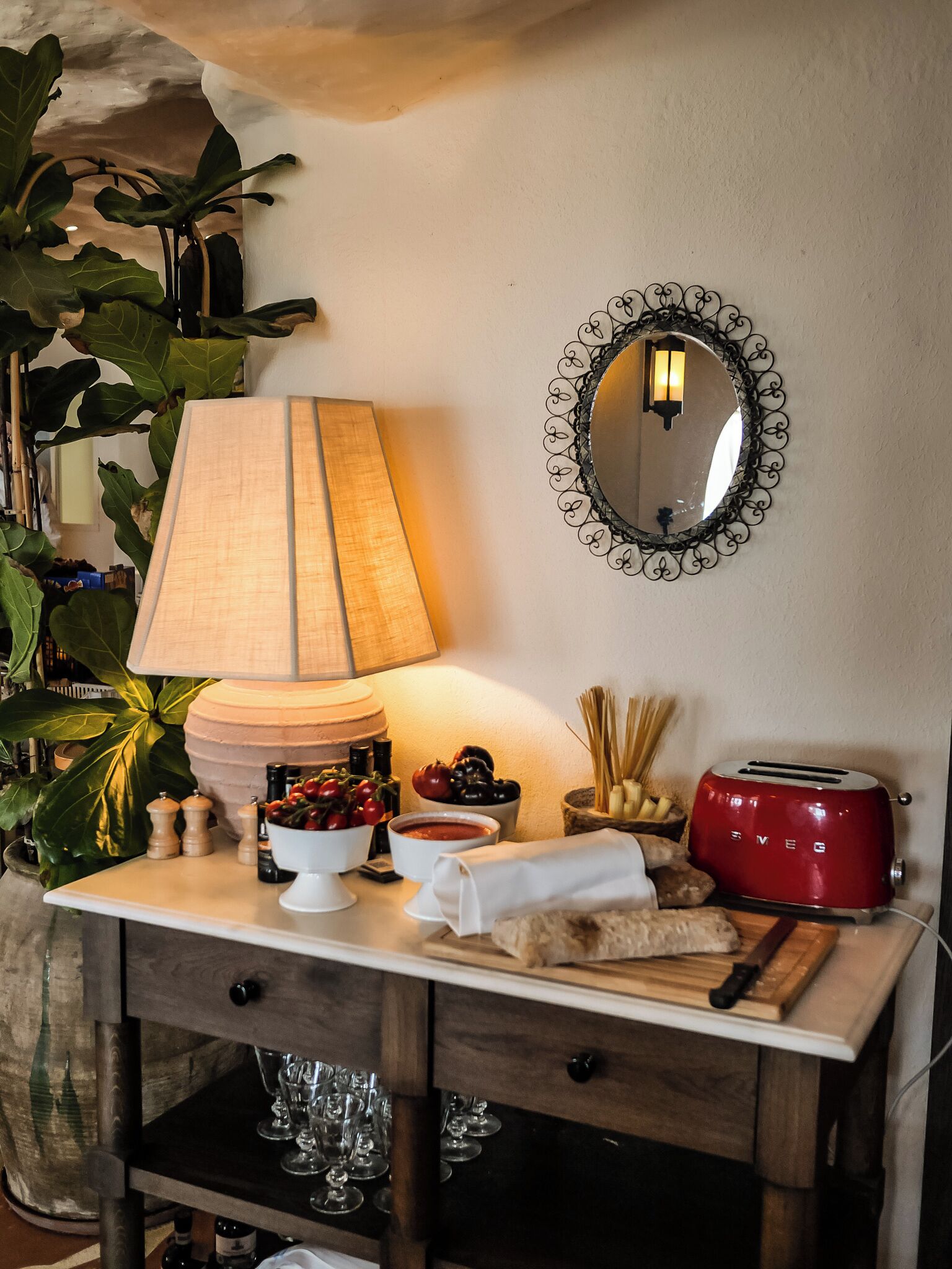 Uma bancada de cozinha com uma luminária, uma torradeira e diversos alimentos.