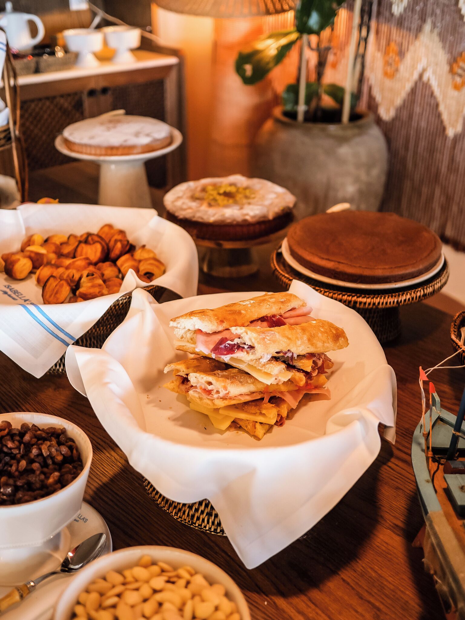 Un bufé de desayuno con diversas opciones de comida, como pasteles, sándwiches y tazones de frijoles.
