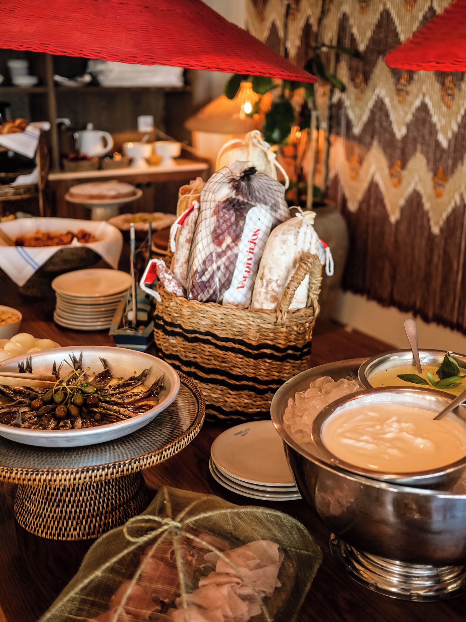 A buffet table with various dishes, including seafood, bread, and a bowl of soup.