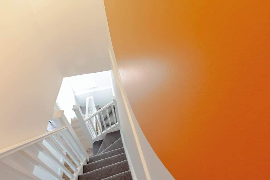 Un escalier avec des rampes blanches et un revêtement de sol en moquette.