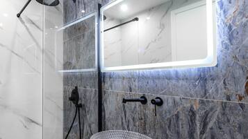 Habitación Deluxe | Baño | Ducha y cabezal de ducha tipo lluvia