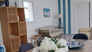 Un comedor con una mesa de madera, flores blancas y un cuenco azul y blanco estampado.