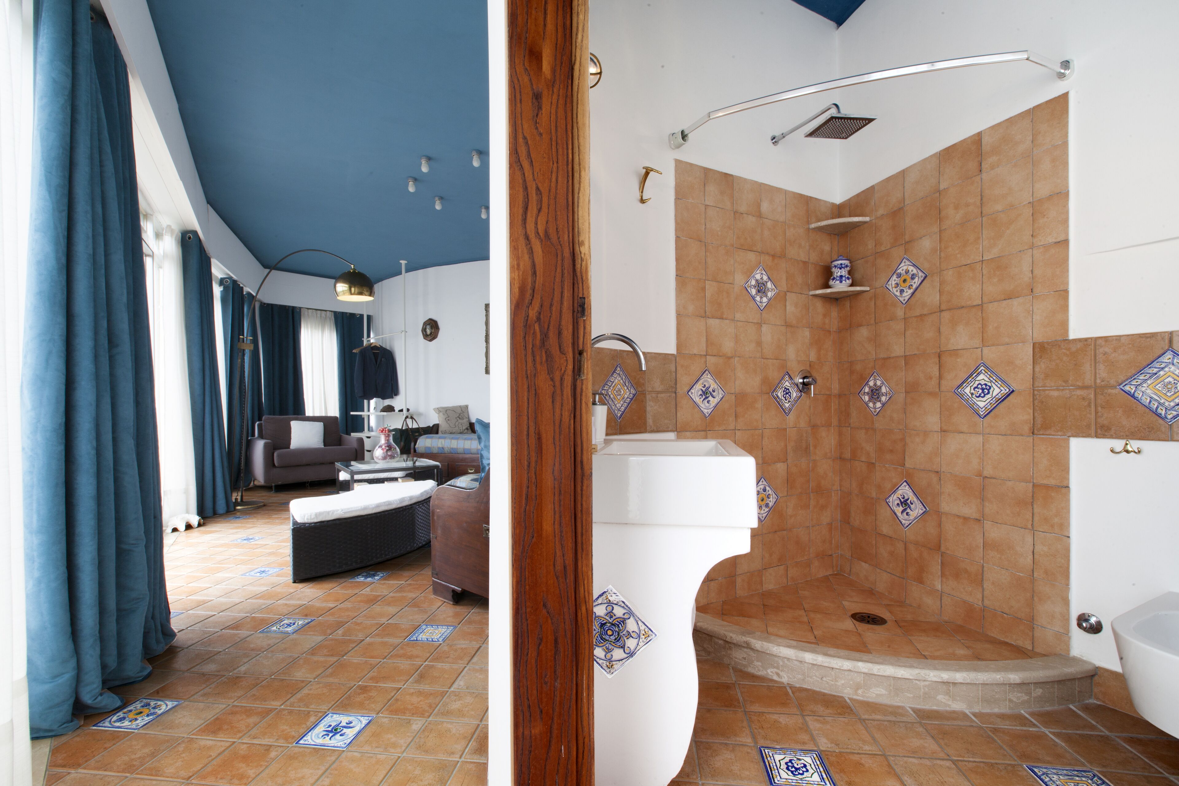 Un salon moderne comprenant un canapé, une table basse et un coin repas. Il comprend également une salle de bain avec une douche, un lavabo et une baignoire.