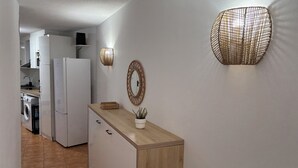 A kitchen with a washing machine, a refrigerator, and a wooden cabinet. - The Vistamar Suite 154 (Tacoronte)