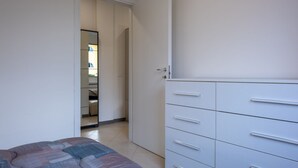 A bedroom with a bed, a wardrobe, and a door leading to a bathroom.